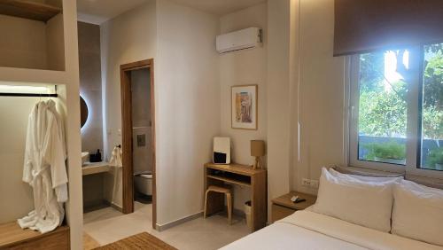 a bedroom with a bed and a desk and a window at OASIS Central 007 in Rhodes Town