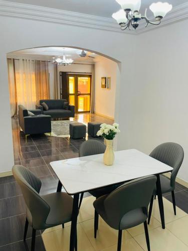 a dining room with a white table and chairs at Joyet Guest House in Amasaman