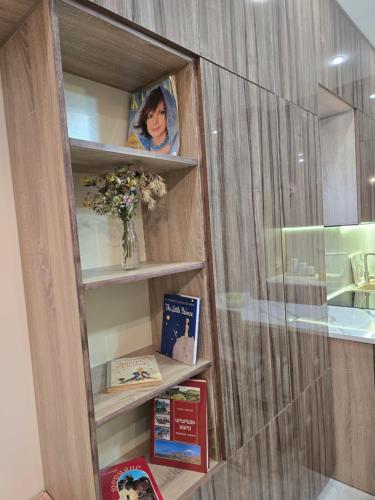 a book shelf with books and a vase of flowers at T'teni in Urtsʼadzor