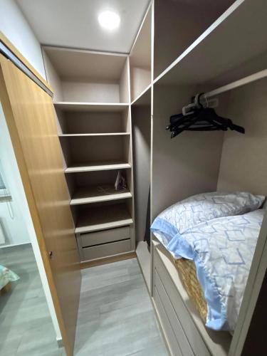 a walk in closet with a bed and shelves at Casa Costa in Esmoriz