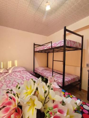 two bunk beds in a room with flowers on the floor at Tamari in Ureki