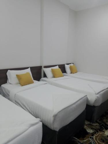 a group of three beds sitting next to each other at فندق بلورة البشاير in An Naqāʼ