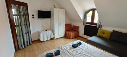 a bedroom with a bed and a couch and a chair at Hársfaapartman és vendégház in Gyula