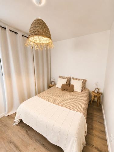 a bedroom with a bed with a teddy bear on it at Appartement cosy Beaupréau centre in Beaupréau