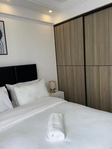 a bedroom with a white bed with a wooden wall at Unique one bedroom with pool in Nairobi