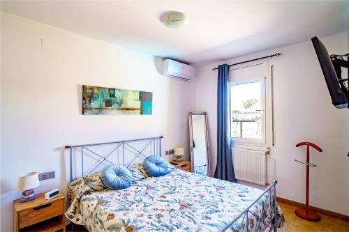a bedroom with a bed with blue pillows on it at Casa Tati Strand in Sant Pere Pescador