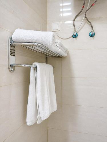 a bathroom with white towels on a towel rack at فندق تلاق للخدمات الفندقيه in Medina