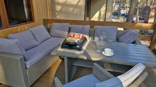 a table with a couch and chairs on a patio at Chata Veverka in Doksy