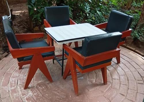 three chairs and a table and a table and chairs at Safari Resot Star One in Moshi