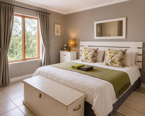 a bedroom with a large bed and a window at The Upper Deck Apartment in Swellendam