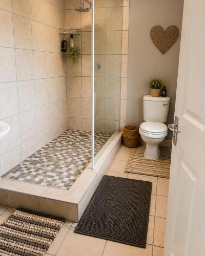 a bathroom with a shower with a toilet at The Upper Deck Apartment in Swellendam