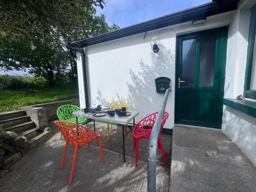 a patio with a table and chairs and a door at The Tailor's Cottage in Lahinch