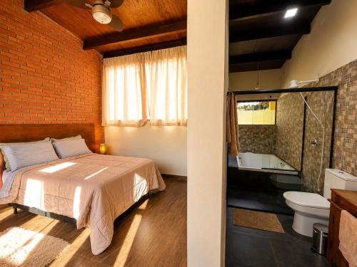 a bedroom with a bed and a bathroom at Jardim Mirim in Cananéia