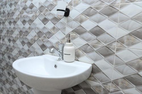 a white sink in a bathroom with tiled walls at Kilimavista Homes studio D2 in Kimana