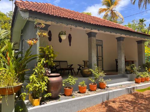 a house with potted plants in front of it at Birdsong Villa Private Garden Retreat in Ratgama Hegoda