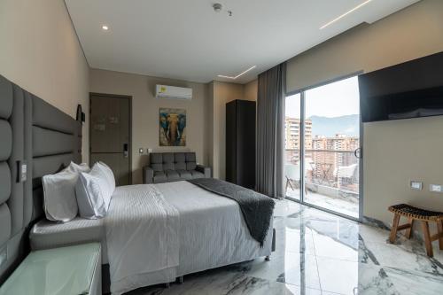 a hotel room with a bed and a large window at Hotel Colores Estadio in Medellín