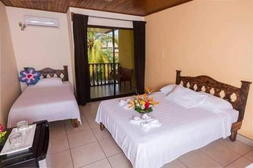 a bedroom with two beds and a balcony at Hotel La Punta in Puntarenas
