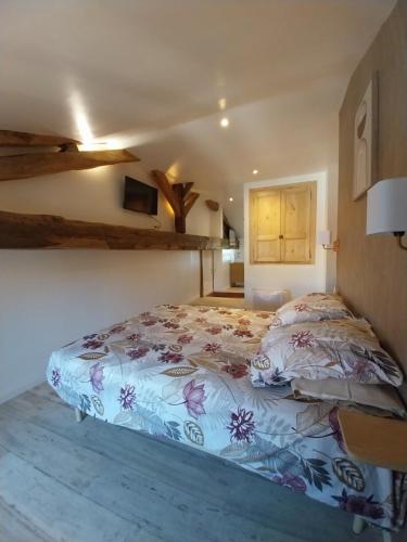 a bedroom with a bed with a floral bedspread at Le sabot de Madame in Lussac-les-Châteaux