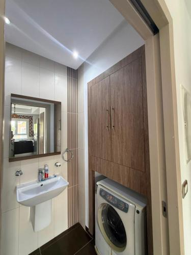 a bathroom with a washing machine and a sink at Triplex résidence tilel chott mariem in Sousse