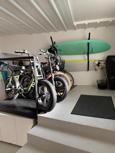 two motorcycles parked in a room with a surfboard at Surf Sea and Sun in Biarritz