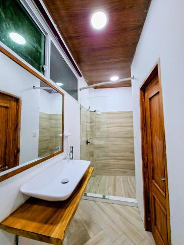a bathroom with a white sink and a shower at Suite frente al Mar con Acceso Directo a la Playa in Ballenita