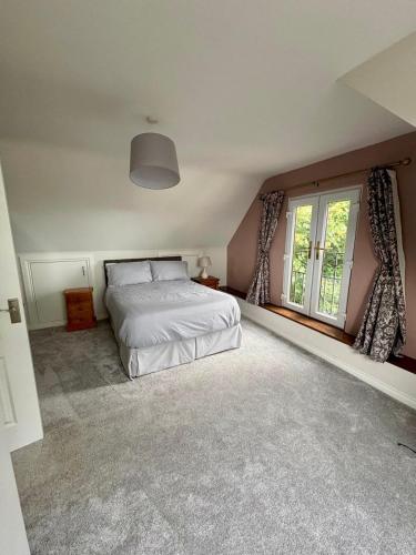a bedroom with a bed and a large window at An Cnocán in Limerick