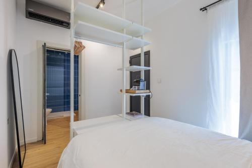 a bedroom with a white bed with white shelves at Casa Lola in Mellieħa