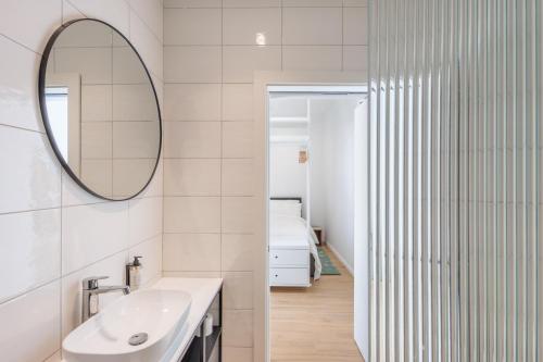 a white bathroom with a sink and a mirror at Casa Lola in Mellieħa