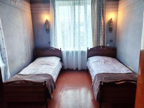 two beds sitting in a room with a window at Meronc Mot Guesthouse in Stepʼanavan