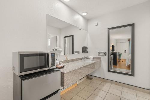 a kitchen with a counter with a microwave and a television at Pine Tree inn in Medford