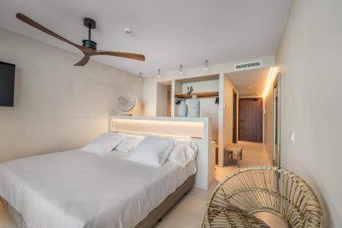 a bedroom with a white bed and a fan at Suites by Miramar - Adults only in Lloret de Mar