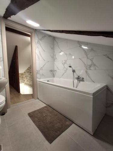 a white bathroom with a tub and a toilet at Villa Ivana in Koper