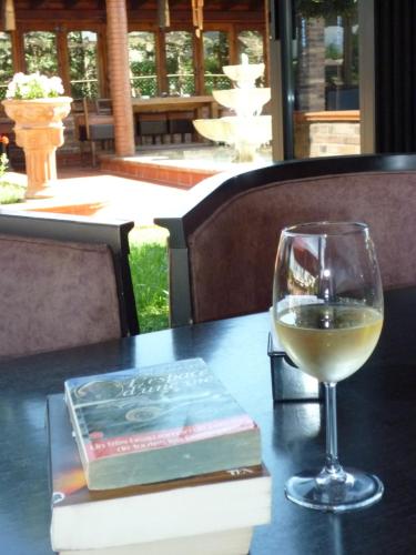 a glass of wine and a book on a table at Drini Hotel in Durrës