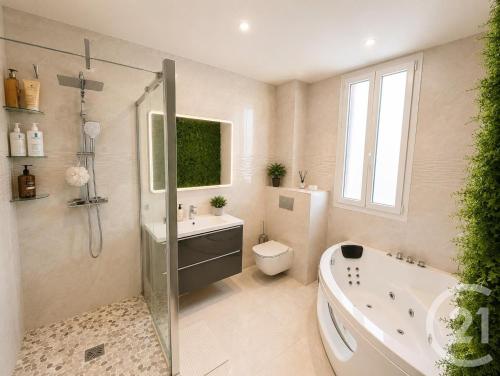 a bathroom with a tub and a toilet and a sink at Livry Gargan in Livry-Gargan