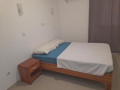 a small bed in a room with a wooden bed frame at Residence du fromager in Bouaké