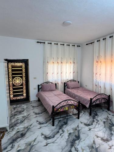 two beds in a room with a marble floor at اطلالة سوف in Jerash