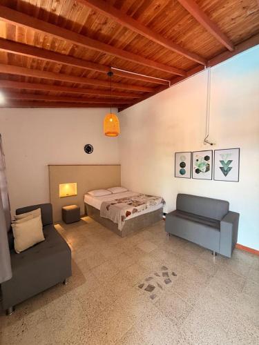 a bedroom with a bed and a couch at Finca Hotel Villa Alba in San Jerónimo