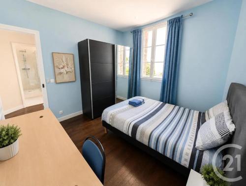 a small bedroom with a bed and a table at Livry Gargan in Livry-Gargan