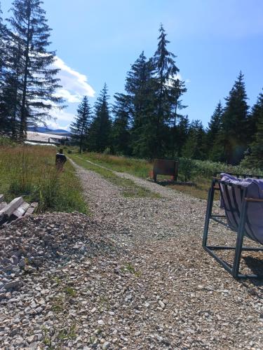 a gravel road with a chair on the side at Chechar Inn Zlatar in Nova Varoš