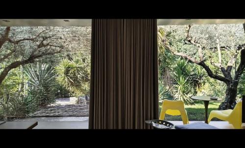 a room with a large window with two yellow chairs at Atelier dei Ciliegi in Cammarata