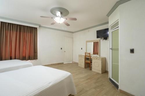 a bedroom with two beds and a ceiling fan at Hotel Real Santa Rosa in Morelia