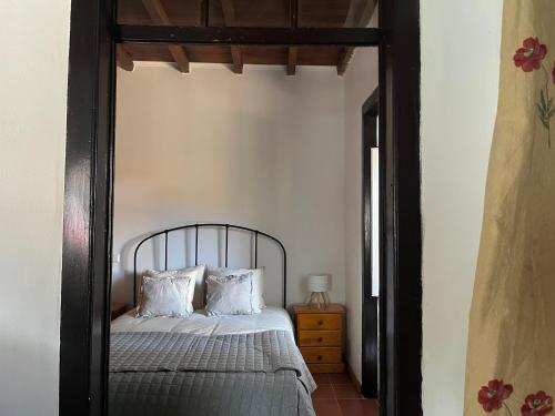 a bed with a black frame in a bedroom at Casa do Caseiro by Quinta da Burra in Cartaxo