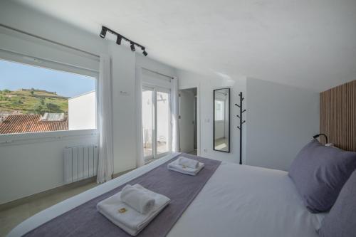 a bedroom with a large white bed with two towels on it at Principado de Aracena I in Aracena