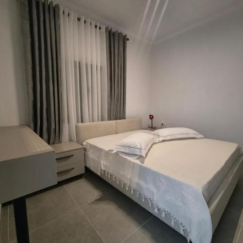 a bedroom with two beds and a window at Kypsel Apartment in Durrës