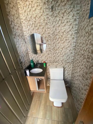 a bathroom with a toilet and a sink and a mirror at Casa da tami in Bonito