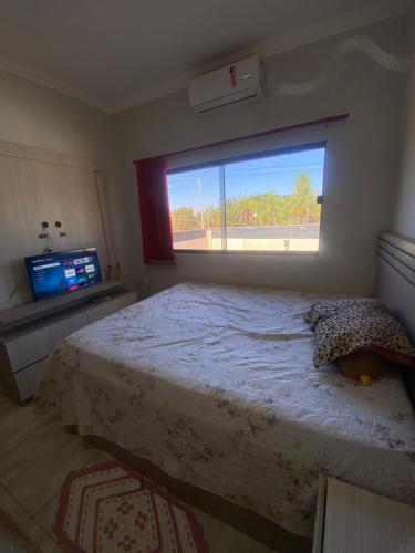 a bedroom with a large bed with a window at Casa da tami in Bonito