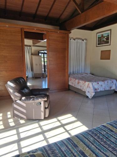 a living room with a bed and a chair and a bedroom at LOFT da Serra Imperial in Petrópolis
