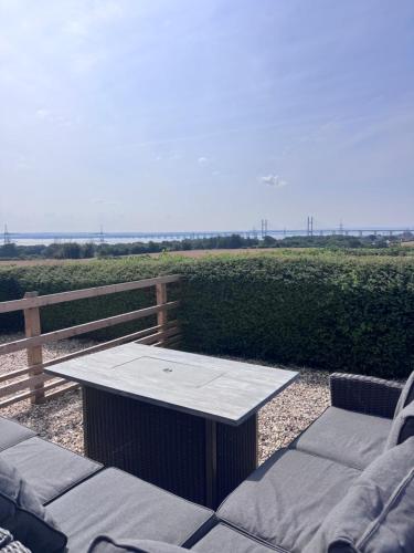 a table and chairs on a patio with a fence at The Barn With A View in Portskewett