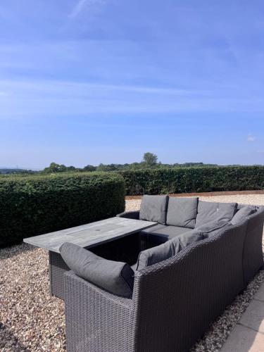 a wicker couch with a coffee table on a patio at The Barn With A View in Portskewett