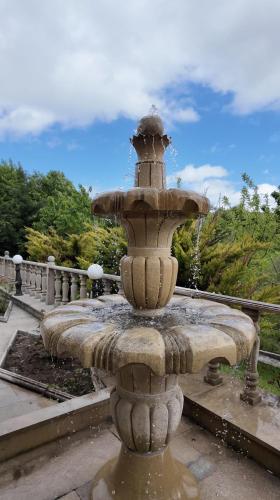 a stone fountain in a park with water coming out at Sadaxlı Hotel & Restaurant in Şǝrǝdil